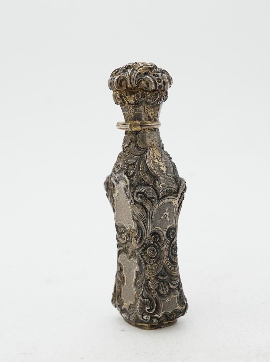 A 19th century French ornate parcel gilt white metal scent flask, with hinged cover and glass stopper